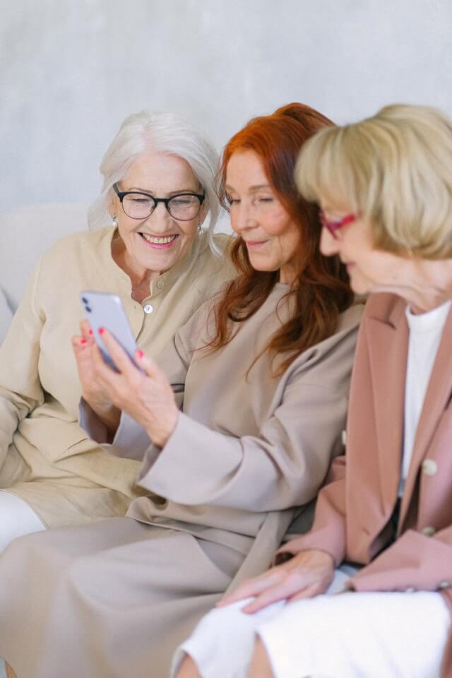 3 ältere Frauen sind beschäftigt am Handy